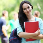 Outdoors portrait of a beautiful tanned teen student girl.